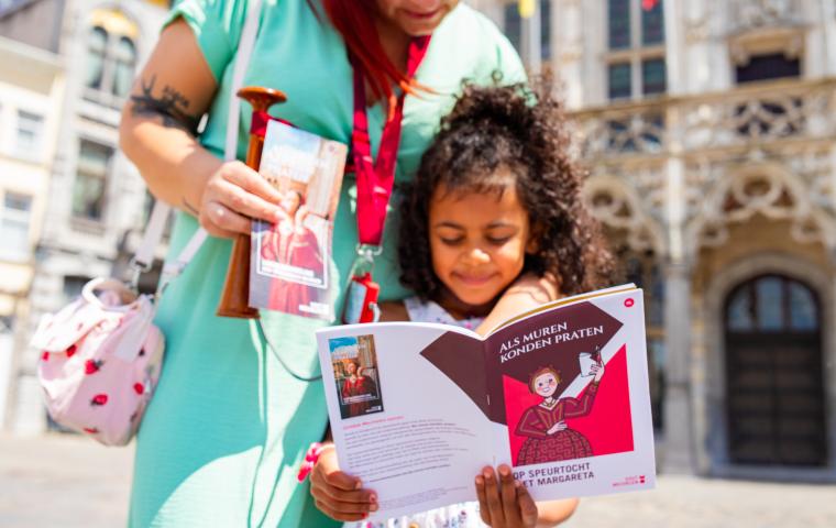 Kindje met de speurtocht brochure in de handen