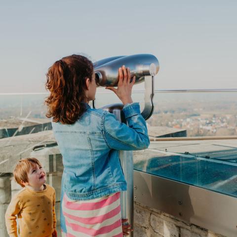 Een kind kijkt door de kijker op de Skywalk van de Sint-Romboutstoren